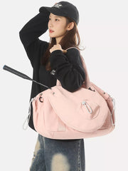 Pink athletic nylon tote bag with racket holder and cinch cord detail.