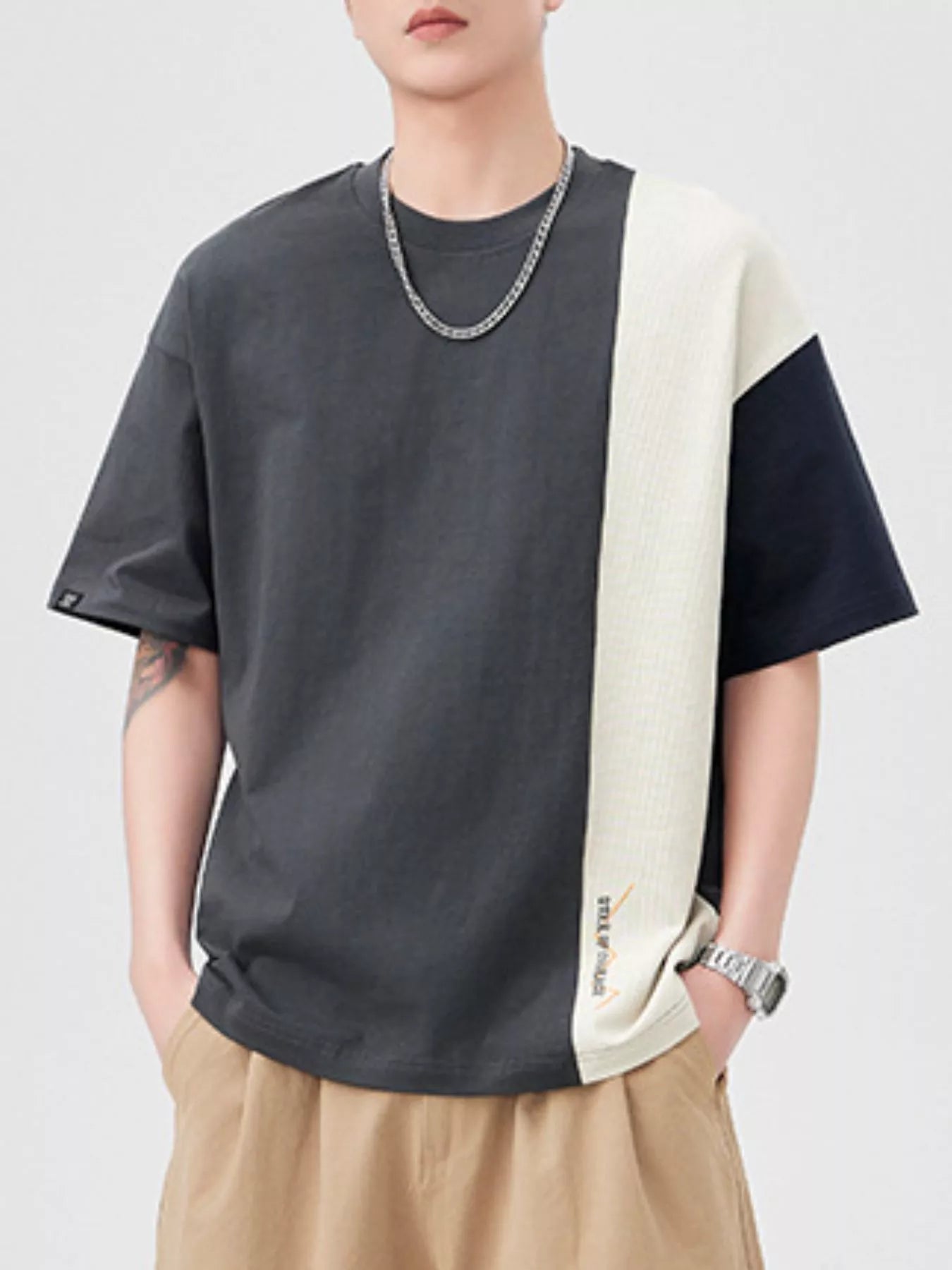 Oversized cotton t-shirt with color block design in dark gray, cream, and navy.
