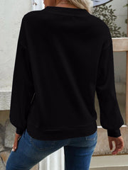 Black waffle knit button-down cardigan with long sleeves and a crew neck.