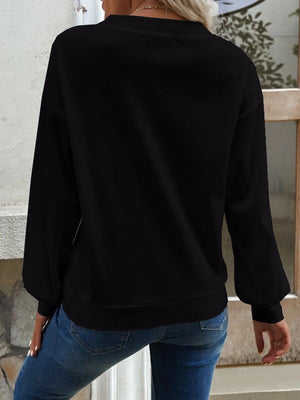 Black waffle knit button-down cardigan with long sleeves and a crew neck.