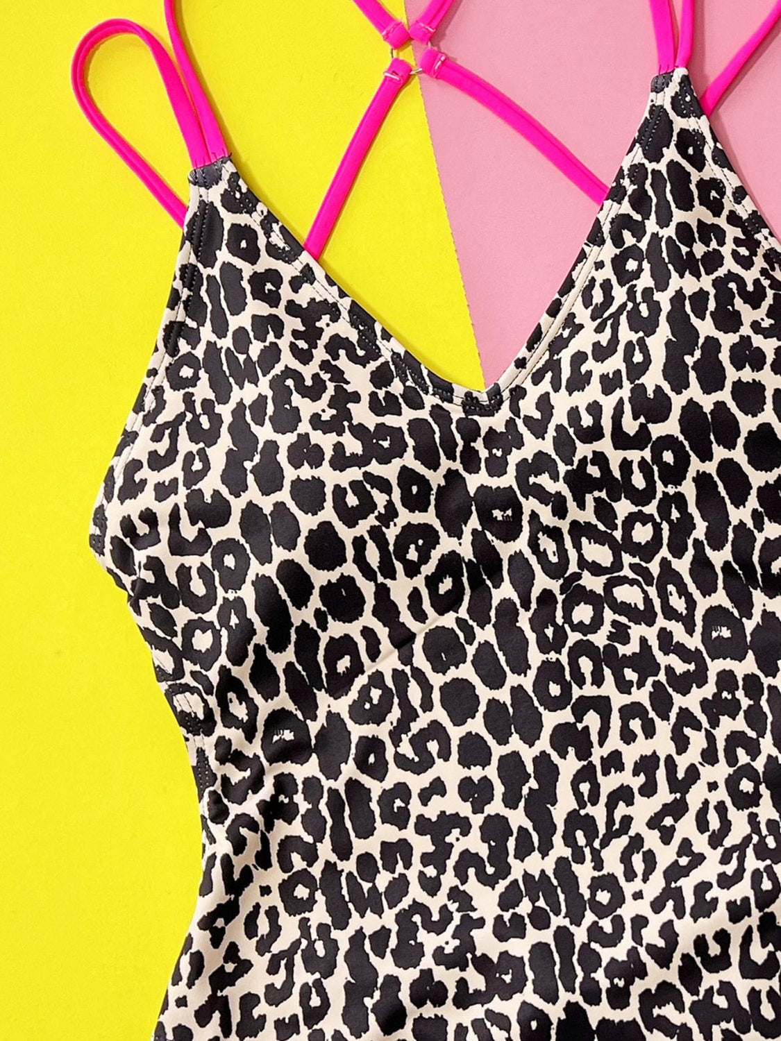 One-piece swimsuit with neon pink strappy back and black leopard print.