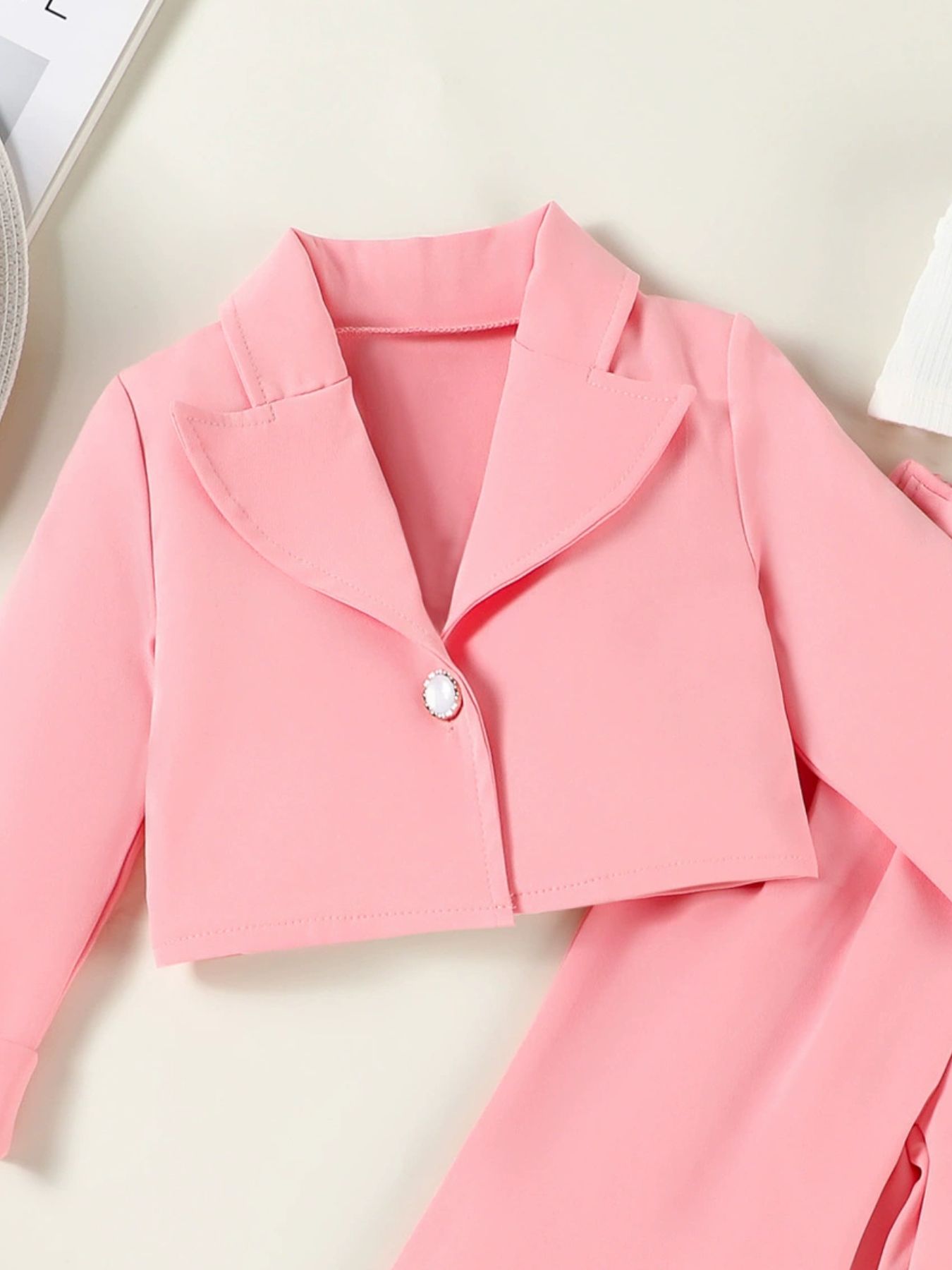 Pink cropped blazer with pearl button detail, part of a toddler outfit set.