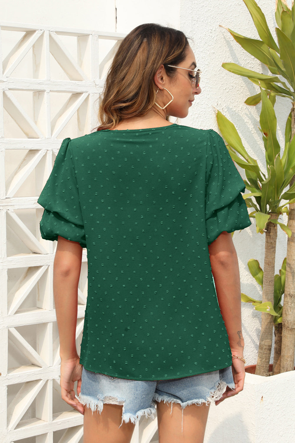 Dark green Swiss dot blouse with tiered short sleeves and a relaxed fit.