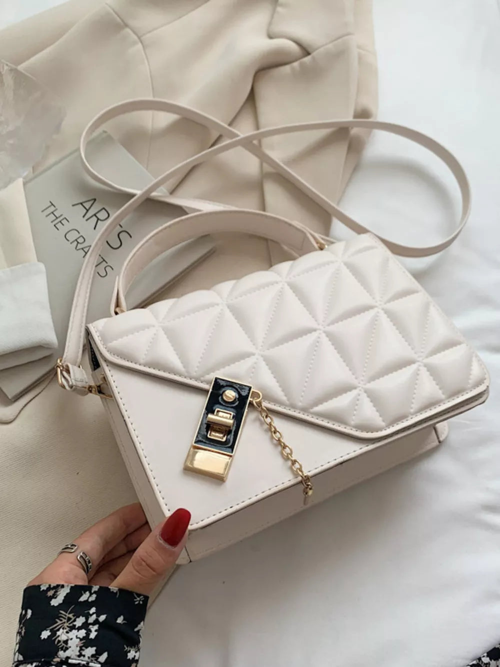 Diamond quilted PU leather crossbody bag in beige white with gold hardware and chain detail.