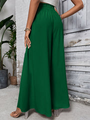 Dark green ruffled waistline palazzo trousers with a wide leg.