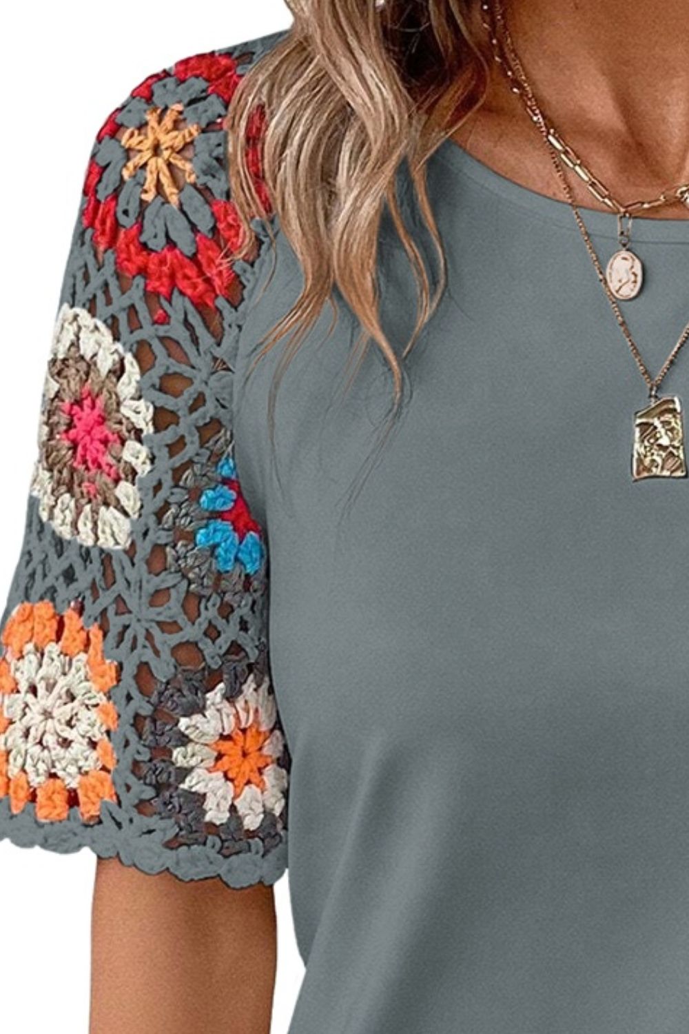 Dark gray t-shirt with colorful granny square crochet sleeves and a crew neck.