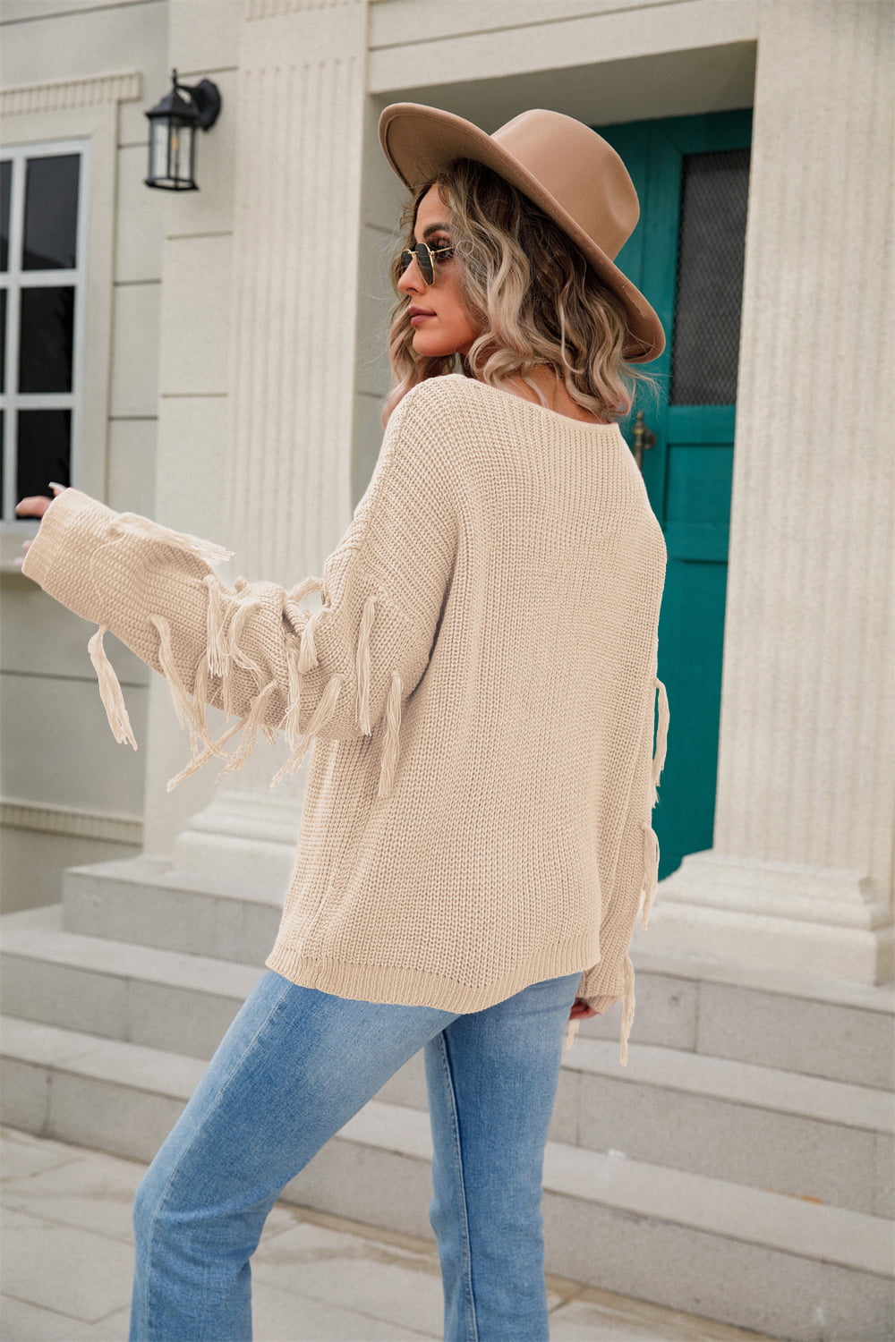 Sand knit sweater with relaxed silhouette and fringe trim sleeves.