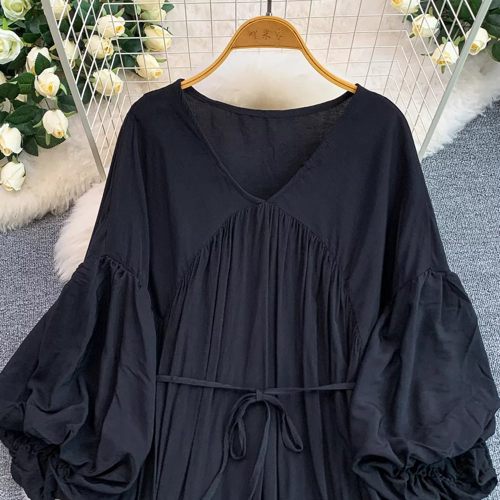 Black bohemian maxi dress with V-neck, cinched waist tie, and voluminous balloon sleeves.