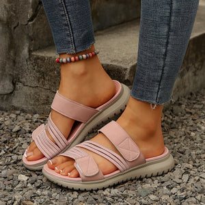 Pink multi-strap sandals with criss-cross elastic bands and adjustable velcro straps.