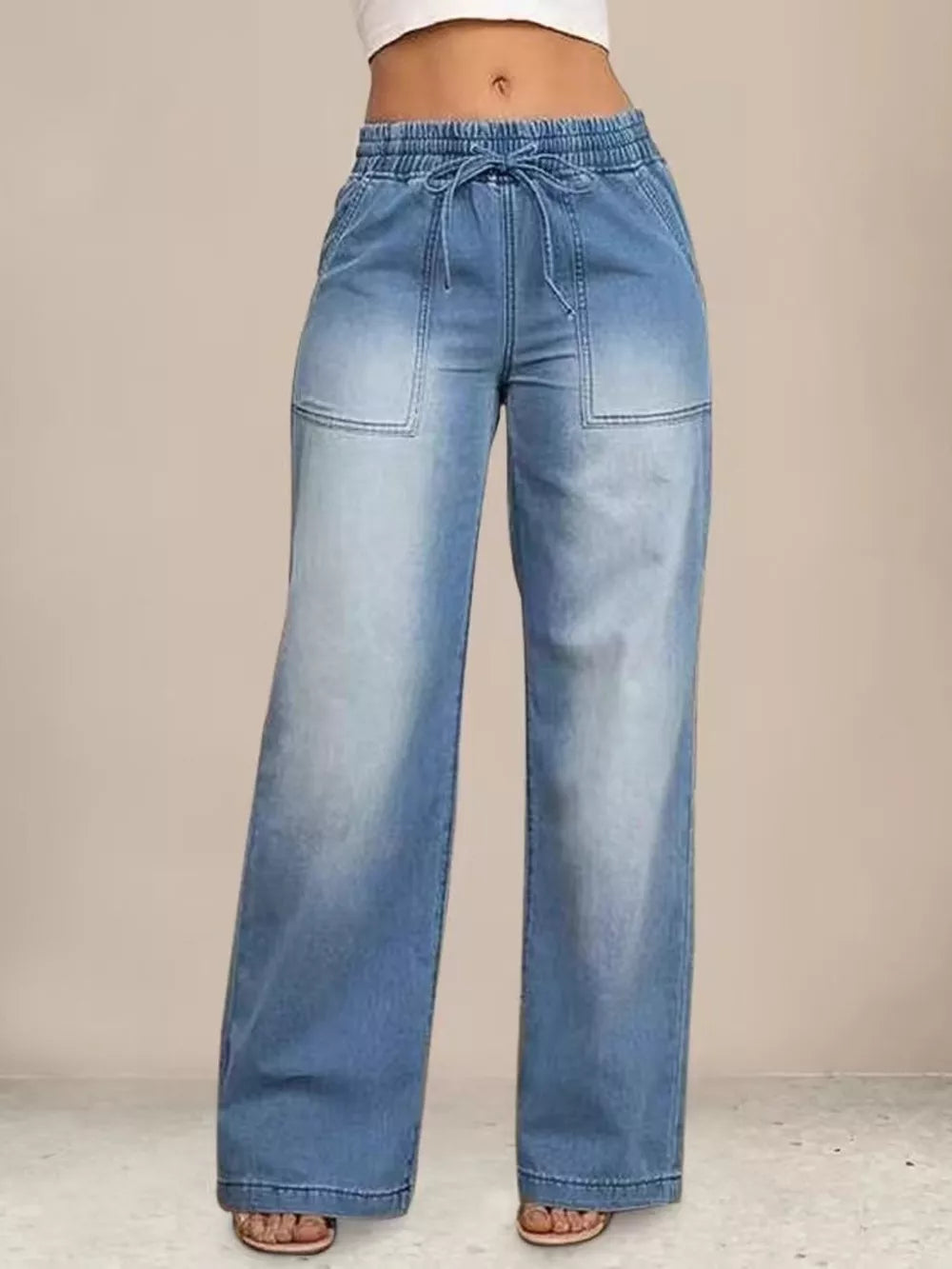 Light blue denim maternity pants with drawstring waist and wide legs.