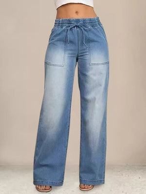 Light blue denim maternity pants with drawstring waist and wide legs.
