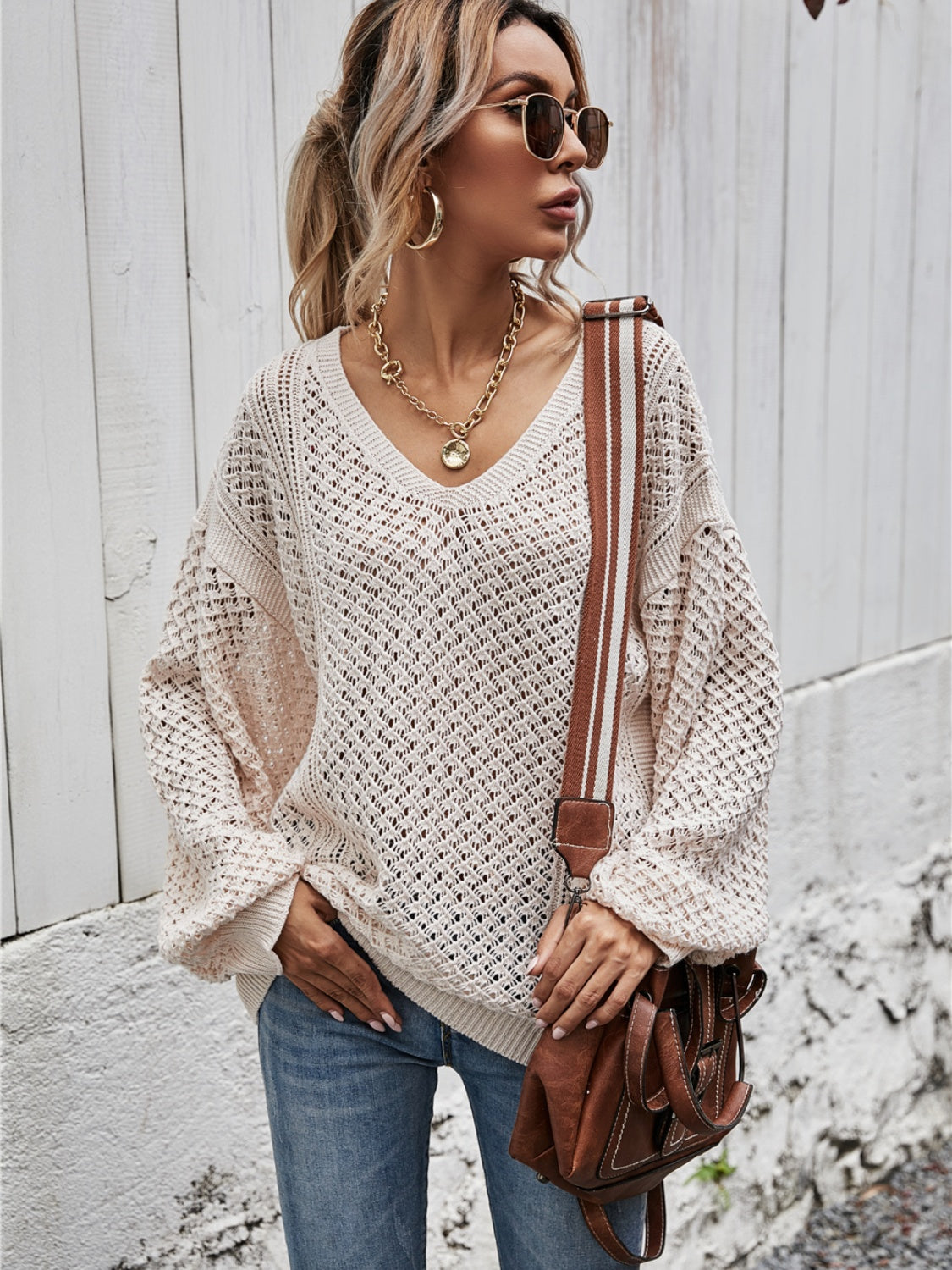 Open-knit sweater in Ivory with balloon sleeves and V-neck, styled with jeans.