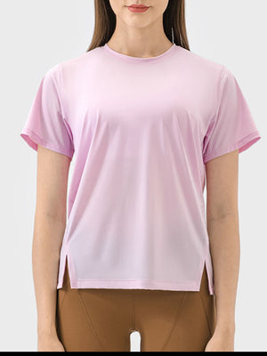 Blush pink performance t-shirt with short sleeves and a slit hem.