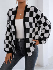 Checkerboard knit cardigan in black and white with balloon sleeves and an open front.