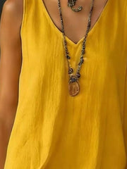 Yellow tiered ruffled hem V-neck dress with a textured fabric and layered necklace.