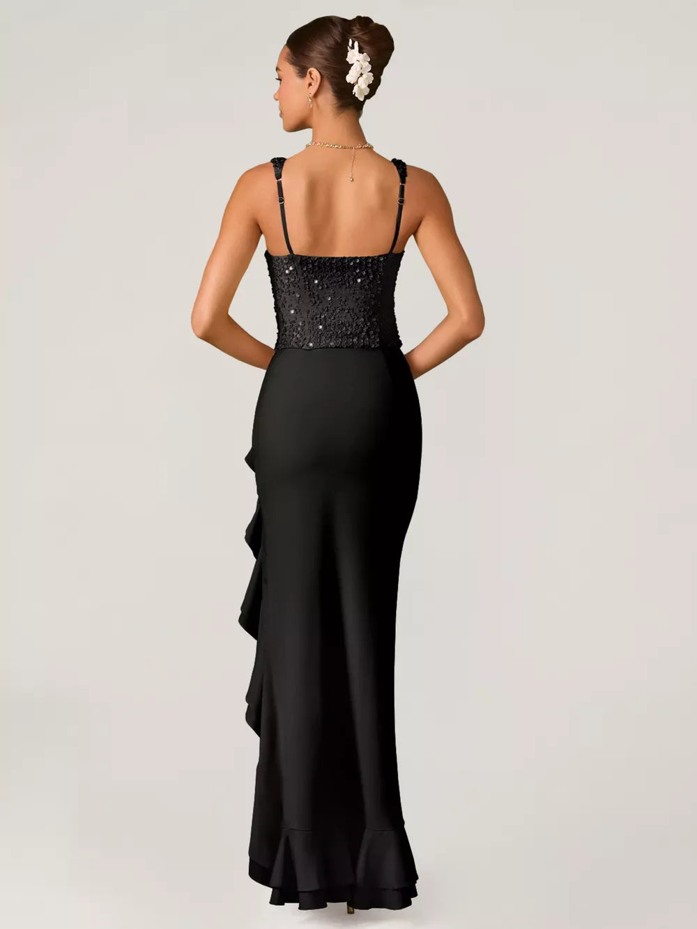 Black sequin ruffle maxi gown with spaghetti straps and a ruffled hem.