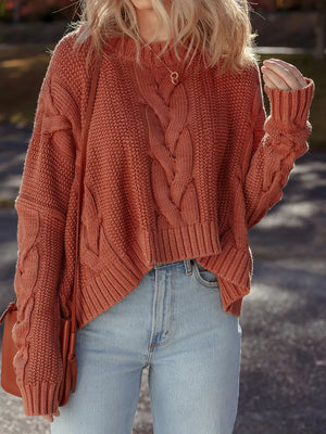 Chunky oversized rust cable-knit sweater with crew neck and cropped hem.