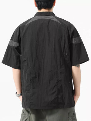 Black short-sleeve polo with quarter-zip, contrast paneling on shoulders and sleeves.