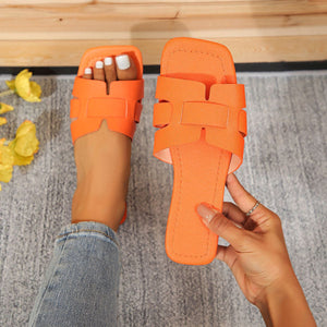 Orange woven strap flat sandals with chic H-design.