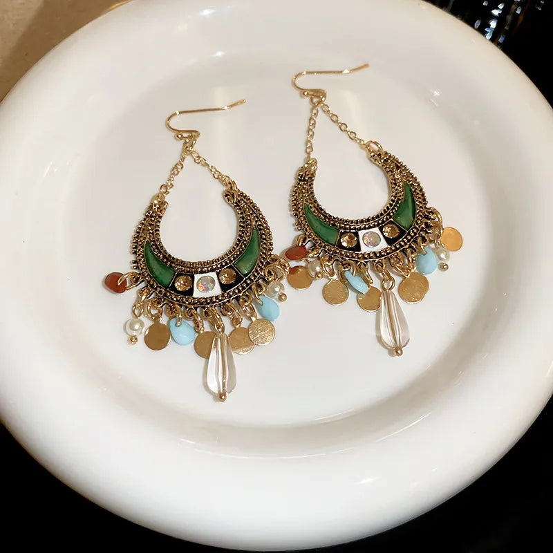 Bohemian crescent drop earrings in dark green with gold alloy, beads, and charms.