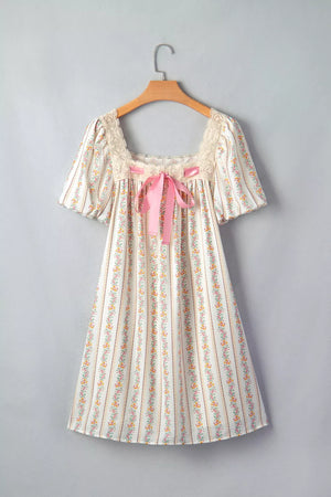 Floral mini dress with lace trim, square neck, puff sleeves, and pink bow detail.