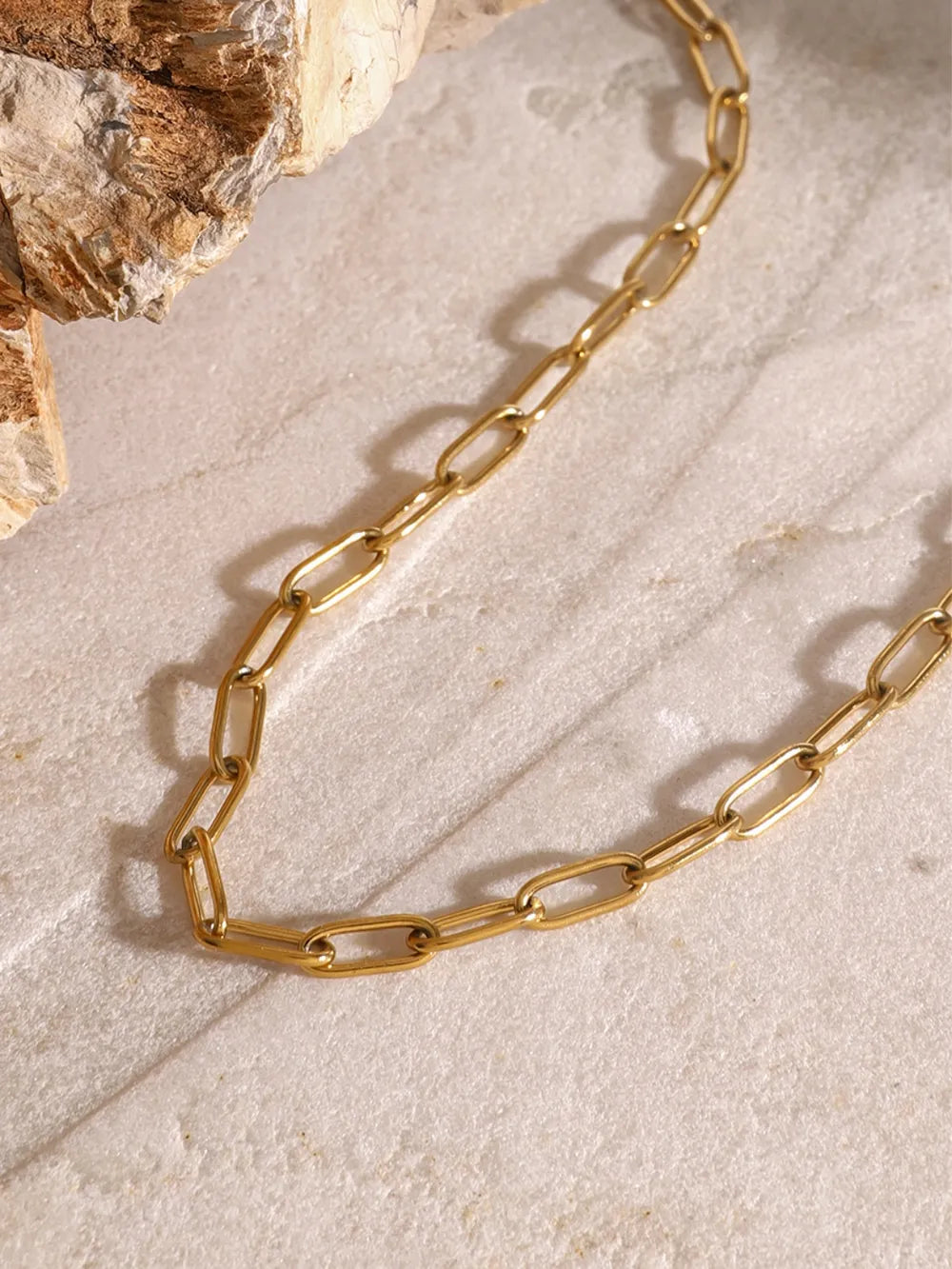 Gold celestial pendant layered chain necklace with delicate paperclip links.