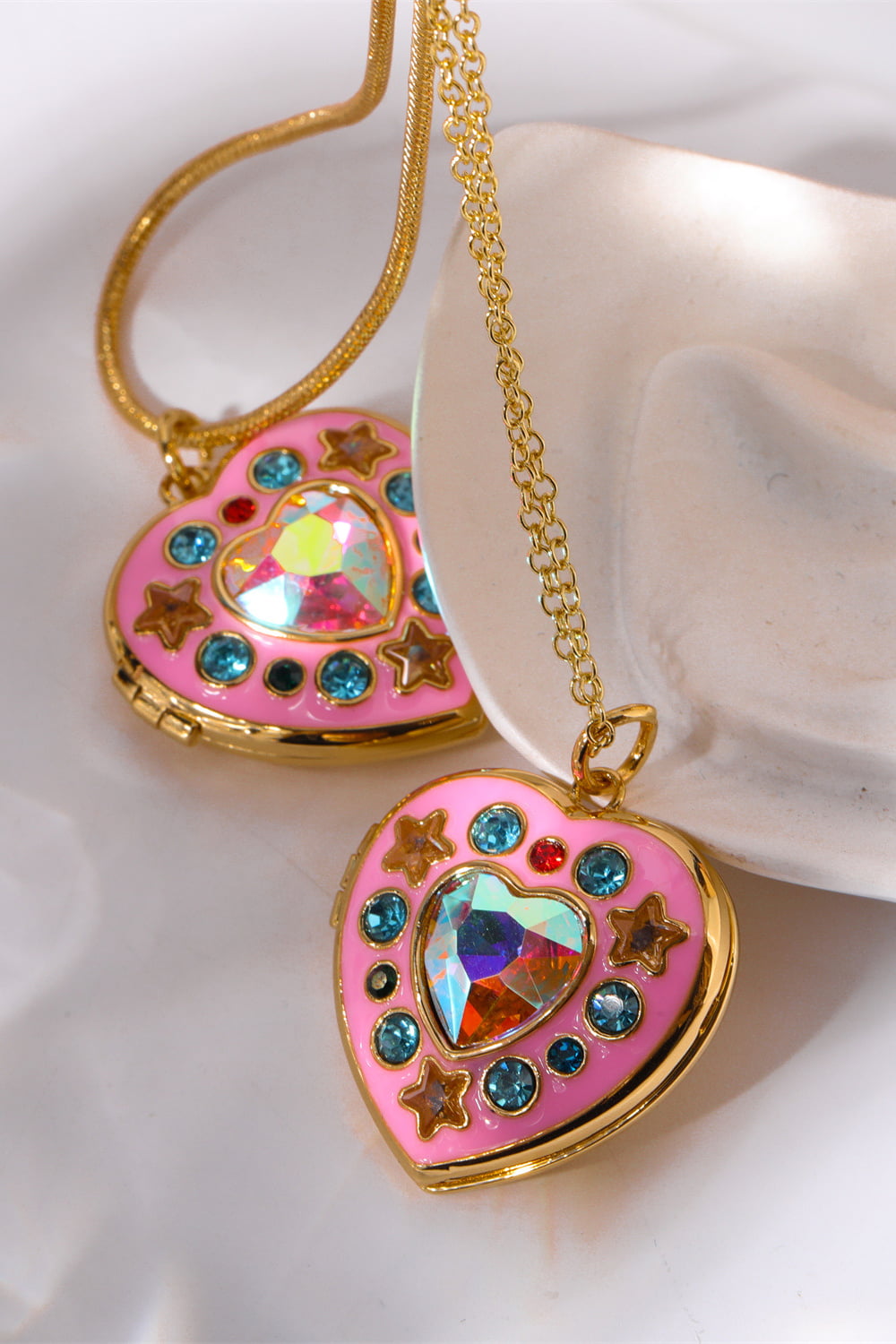 Gold locket heart pendant with pink enamel, iridescent gem, blue and star accents