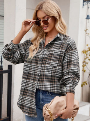 Oversized plaid shirt jacket in brown, black, and white with a chest pocket and buttoned cuffs.