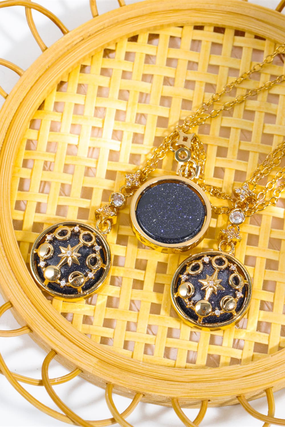 Gold celestial medallion pendant necklaces with blue sandstone and moon phase details.