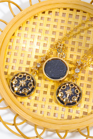 Gold celestial medallion pendant necklaces with blue sandstone and moon phase details.