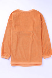 Orange corded long sleeve sweatshirt with ribbed texture and crew neck.