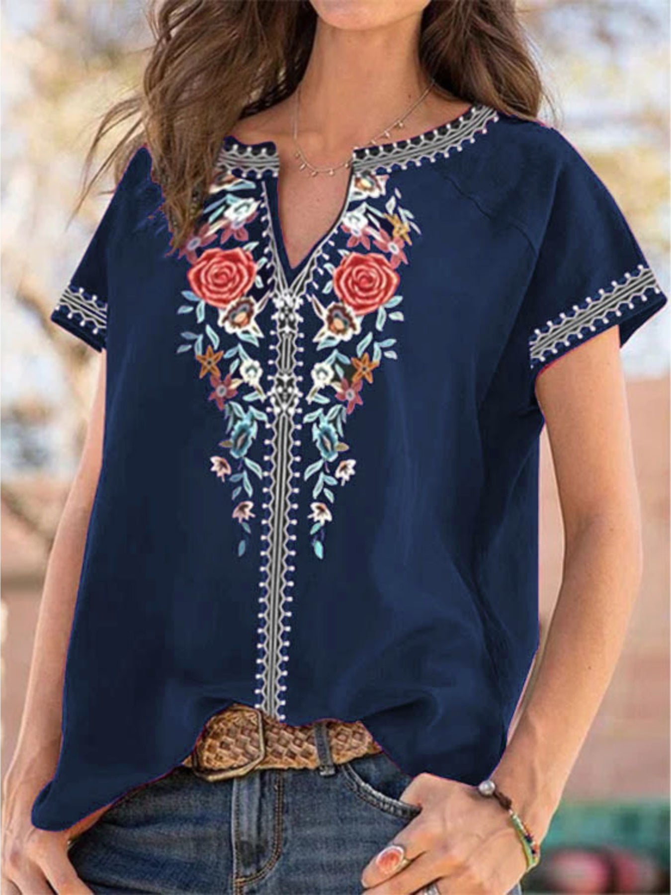 Navy blue blouse with floral embroidery and notched neckline.