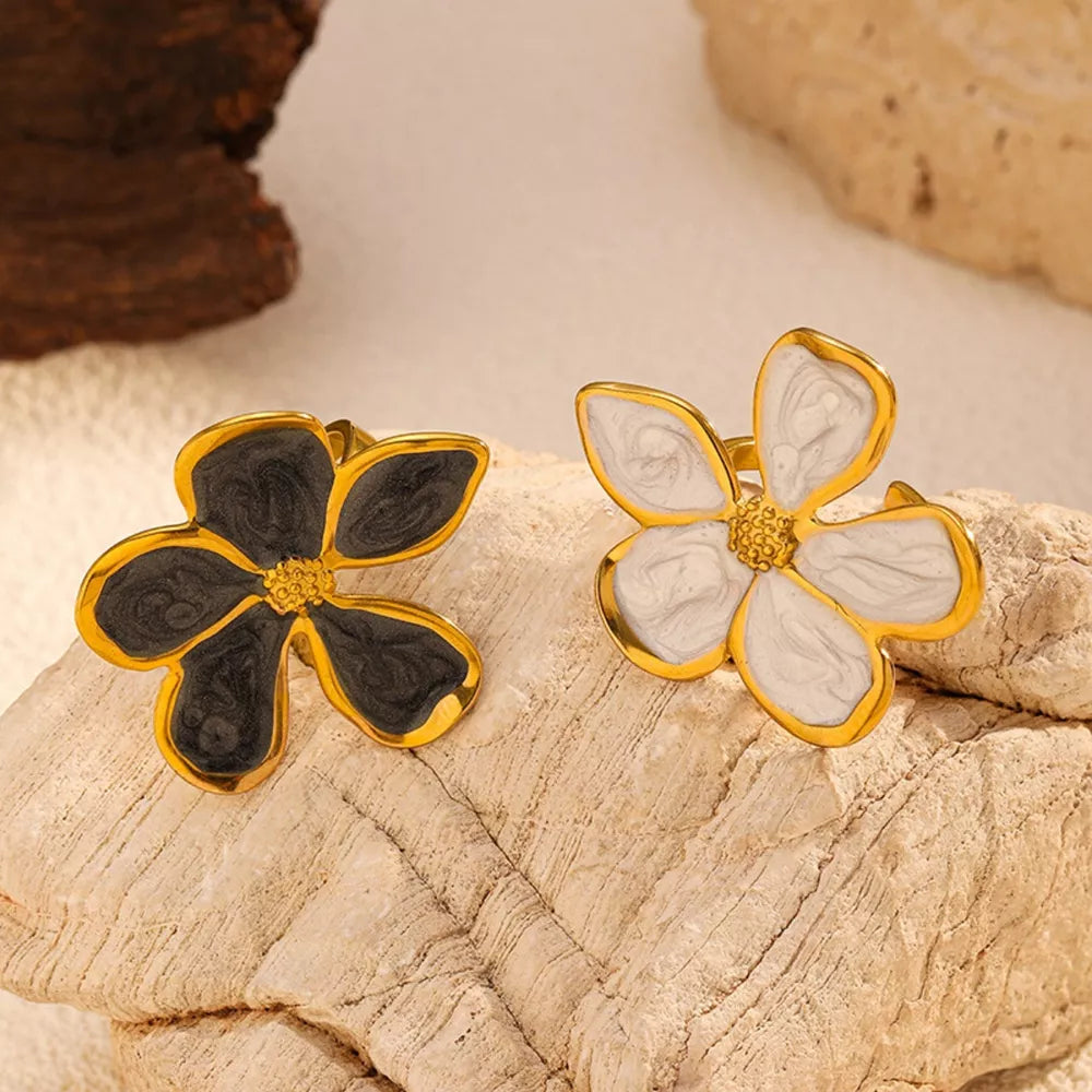 Lustrous floral open ring in gold with cream or dark gray enamel petals.