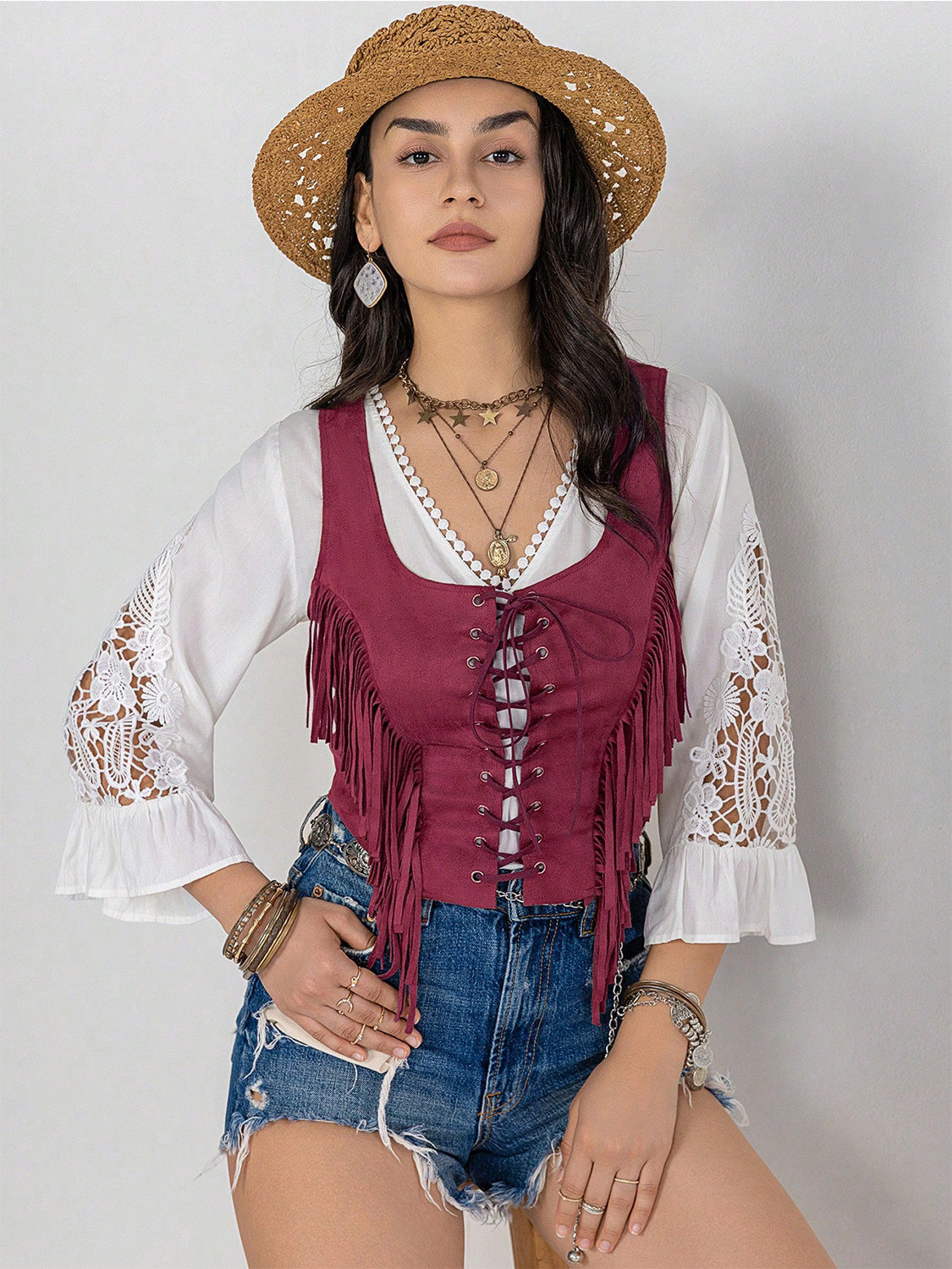Cerise suede lace-up corset vest with fringe detail and boho styling.