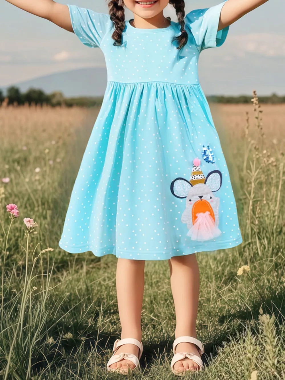 Mint blue polka dot toddler dress with cartoon character applique and short sleeves.