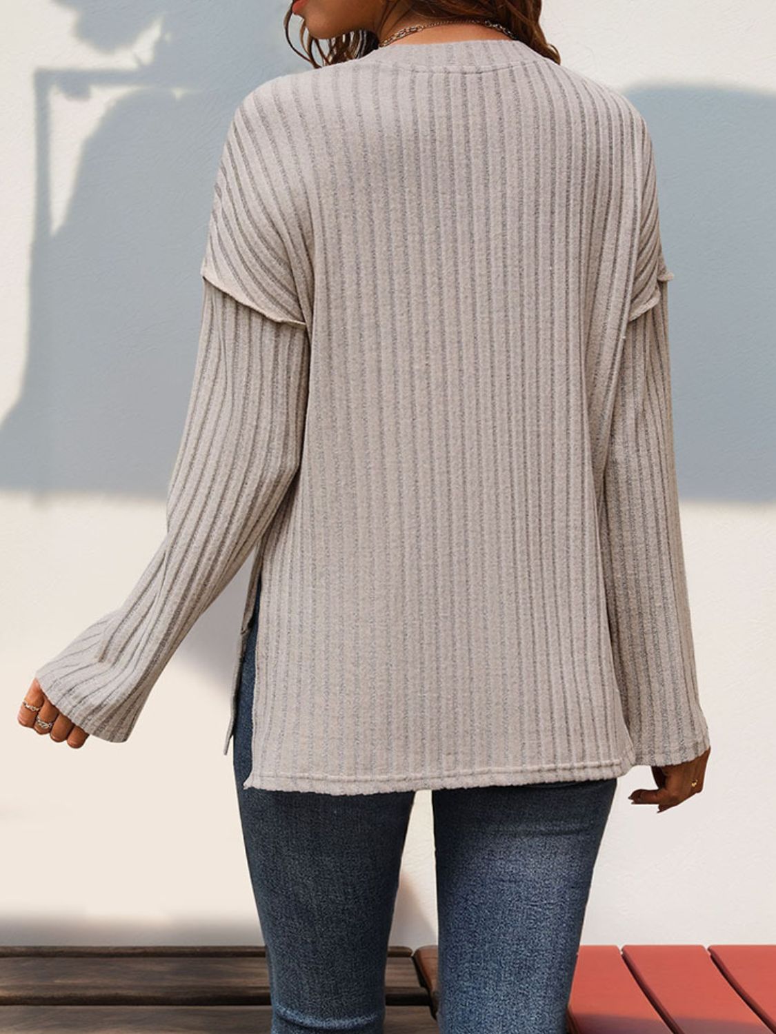 Tan textured henley shirt with flared sleeves and side slits.