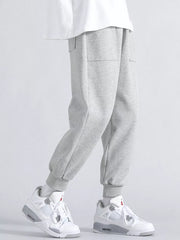 Men's light grey relaxed fit joggers with two front pockets and cuffed ankles.