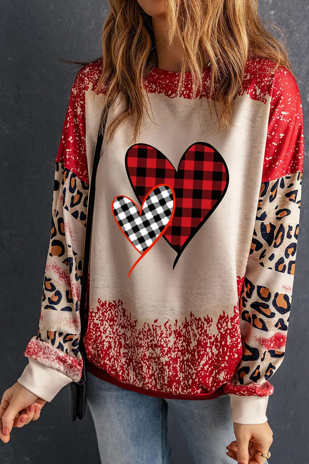 Plaid heart graphic sweatshirt with leopard print sleeves in deep red and beige.