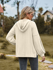 Cream textured knit hoodie with balloon sleeves and a cable knit pattern.