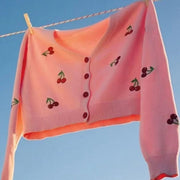 Pink cropped cardigan with cherry embroidery and button front