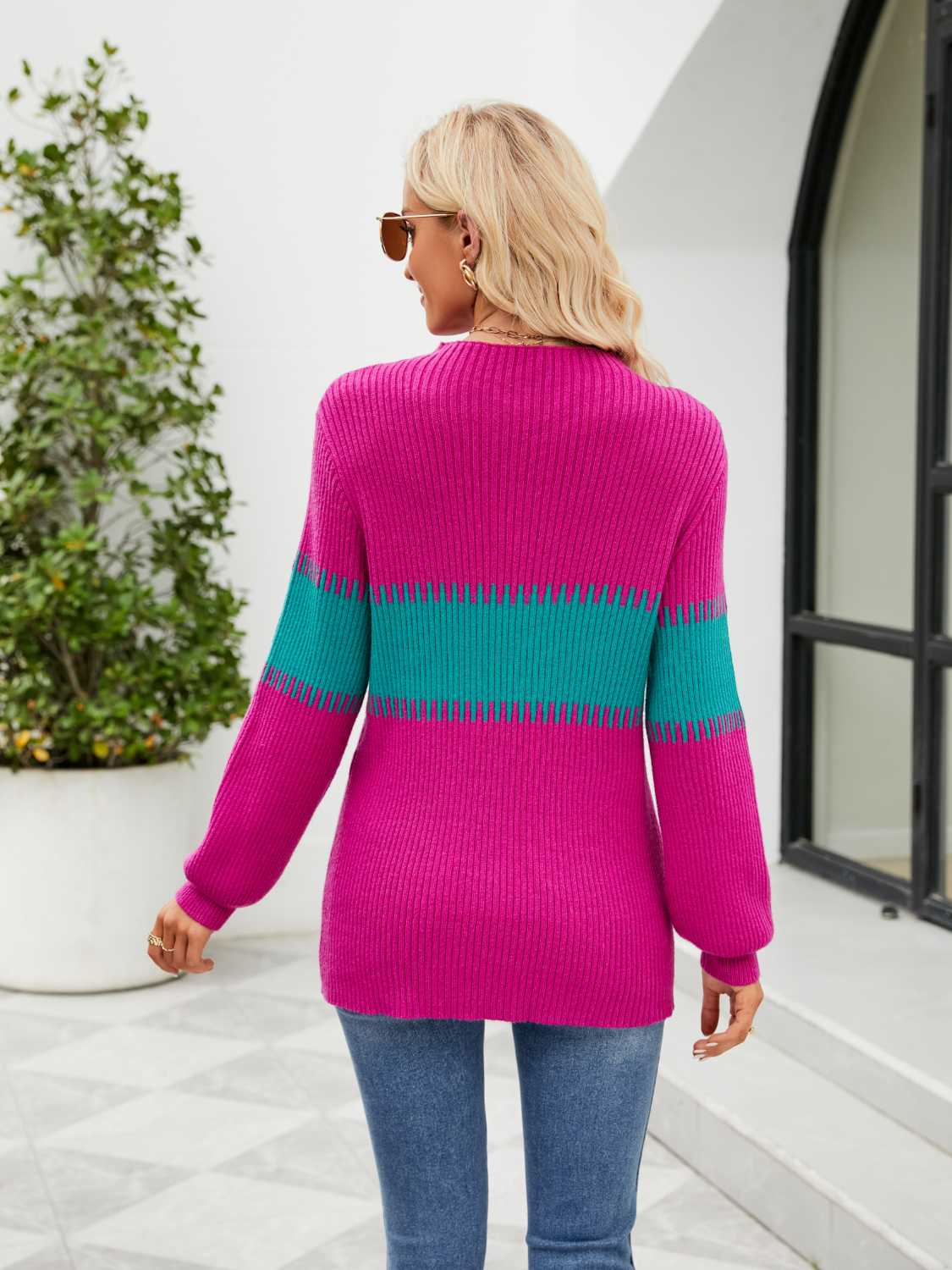 Colorblock ribbed sweater in hot pink with teal stripe detail on sleeves and torso.