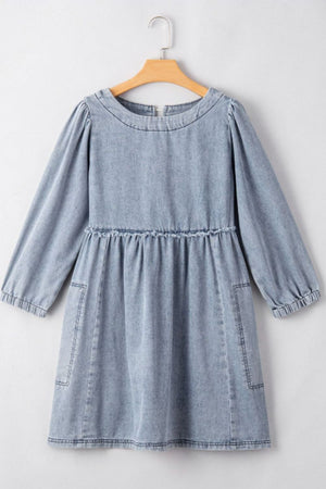 Gathered waist denim mini dress in medium blue with balloon sleeves and pockets.