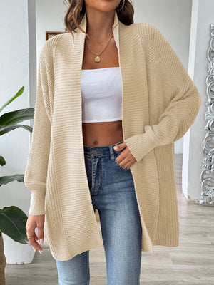 Tan ribbed knit cocoon cardigan with open front and long sleeves, styled with a white crop top and jeans.