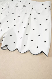 White chino shorts with black polka dots and a scalloped hem detail.