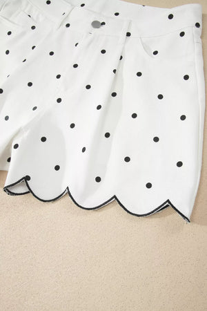 White chino shorts with black polka dots and a scalloped hem detail.