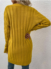 Mustard yellow cable knit button-down cardigan with ribbed texture and long sleeves.