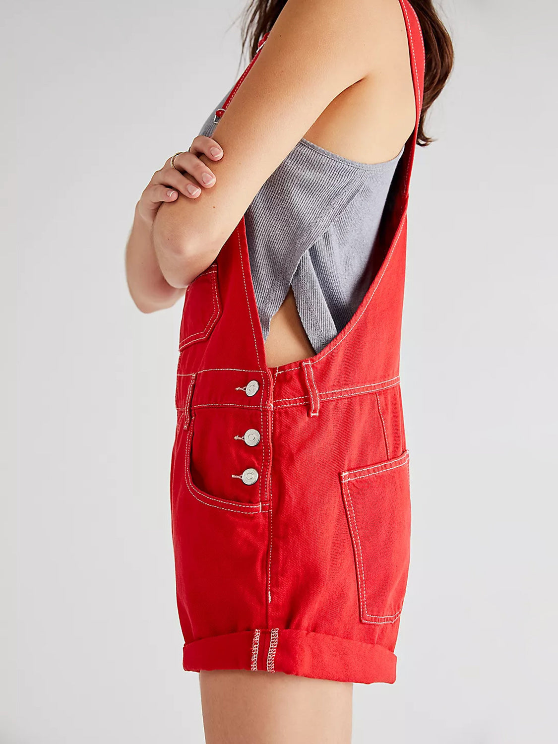 Crimson denim short overalls with contrast stitching and cuffed hem.