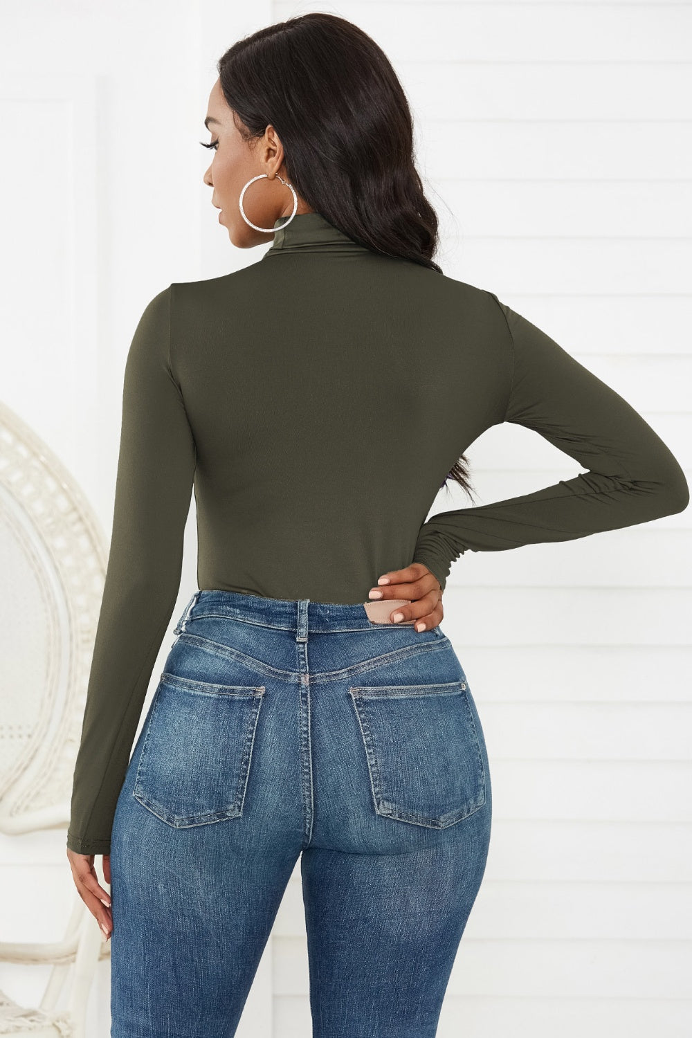 Army green turtleneck thong bodysuit with long sleeves, styled with blue jeans.