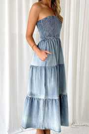Light blue denim strapless maxi dress with smocked bodice and tiered skirt with pockets.