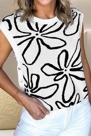 White knit top with black floral print and button detail on the side.